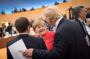 Chancellor Angela Merkel talking to US President Donald Trump and French President Emmanuel Macron before the first meeting of the G20 Summit.