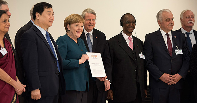 Bundeskanzlerin Angela Merkel erhält ein Kommunique der G20-Akademie der Wissenschaften.