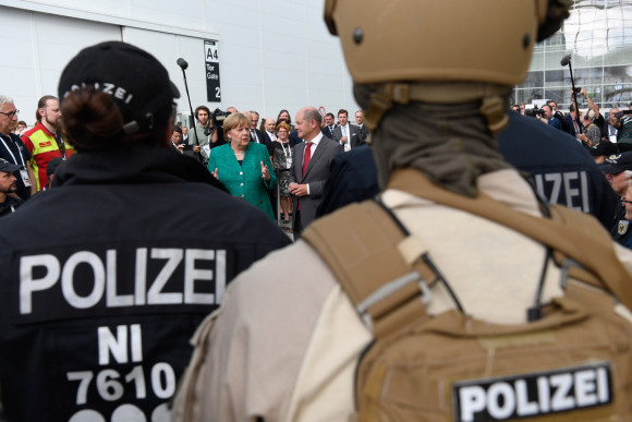 Bundeskanzlerin Angela Merkel im Gespräch mit Sicherheitskräften des G20-Gipfels (daneben Olaf Scholz, Erster Bürgermeister von Hamburg).