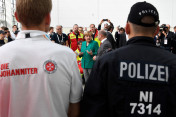 Bundeskanzlerin Angela Merkel im Gespräch mit Sicherheitskräften des G20-Gipfels (daneben Olaf Scholz, Erster Bürgermeister von Hamburg).