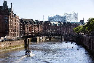 Die Speicherstadt in Hamburg - dahinter sieht man silbern das Gebäude vom Konzerthaus Elb-Philharmonie. 