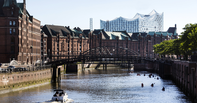Die Speicherstadt in Hamburg - dahinter sieht man silbern das Gebäude vom Konzerthaus Elb-Philharmonie. 