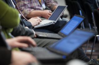 Journalisten arbeiten in einer EU-Pressekonferenz mit Laptop, Computer