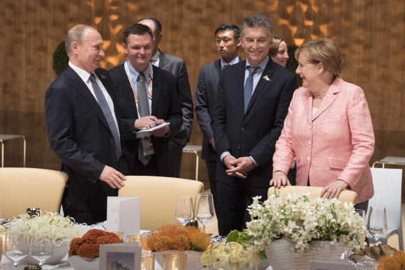 Chancellor Angela Merkel talking to Russia's President Vladimir Putin and the President of Argentina, Mauricio Macri, before the start of the banquet in the Elbphilharmonie.